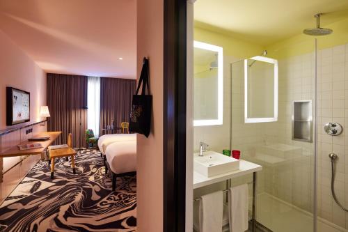 a hotel room with a bed and a bathroom at Mama Shelter Belgrade in Belgrade
