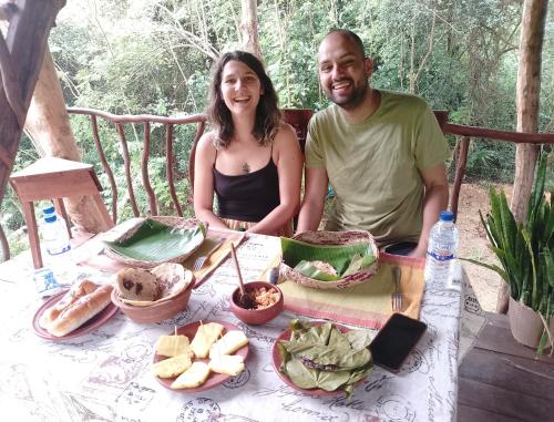 a man and a woman sitting at a table with food at Atha Tree House in Habarana