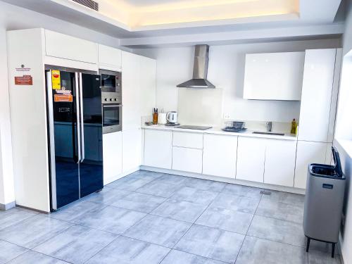 a kitchen with white cabinets and a refrigerator at Accra Luxury Apartments at Lul Water in Accra