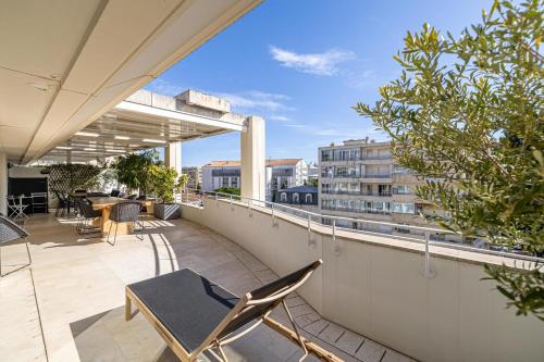 un balcon avec des chaises et des tables sur un immeuble dans l'établissement REF 823 - Cannes Center - Duplex apartment for rent, à Cannes
