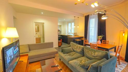 un salon avec un canapé et une télévision à écran plat dans l'établissement 6 Chic spacious Flat Moulin rouge, à Paris