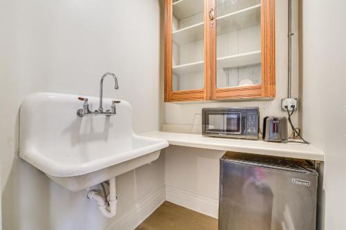 a bathroom with a sink and a microwave at Walkable Main Street Location Spring Grove Apt in Spring Grove