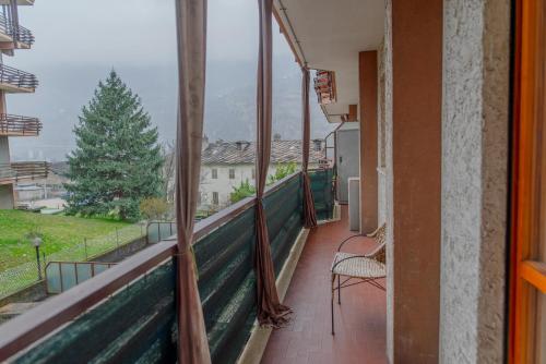 a balcony with a chair and a view of a mountain at The Valley Escape in Chiomonte
