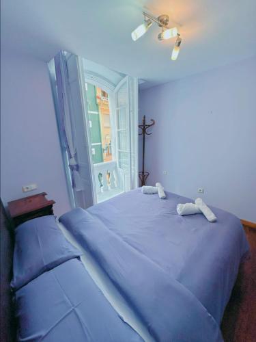 a blue bed in a room with a cross on the wall at La Maresía in Cudillero