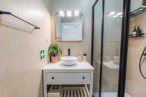 ein Badezimmer mit Waschbecken und Glasdusche in der Unterkunft Casa da Madrinha in Fenais da Ajuda