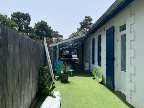 une arrière-cour d'une maison avec une clôture et une pelouse dans l'établissement Maison Petite Bleue piscine privée chauffée, à Lacanau-Océan