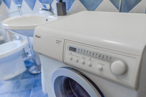 a washing machine in a bathroom with a sink at The Valley Escape in Chiomonte