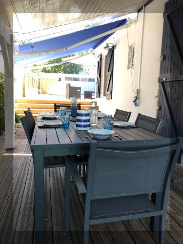 une table bleue et des chaises assises sur une terrasse dans l'établissement Maison Petite Bleue piscine privée chauffée, à Lacanau-Océan
