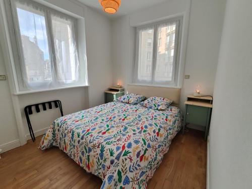 - une chambre avec un lit avec une couette et 2 fenêtres dans l'établissement L'hermine, à Saint-Malo