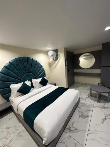 a bedroom with a large bed and a table at Hotel Shyam Paradise in Vadodara