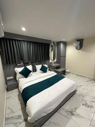 a bedroom with a large bed in a room at Hotel Shyam Paradise in Vadodara