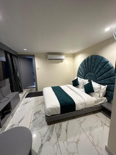 a bedroom with a large bed with a blue headboard at Hotel Shyam Paradise in Vadodara