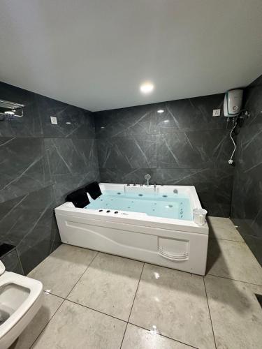 a bath tub in a bathroom with a sink at Hotel Shyam Paradise in Vadodara