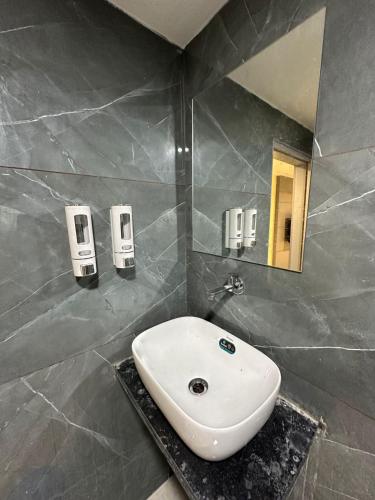 a bathroom with a sink and a mirror at Hotel Shyam Paradise in Vadodara