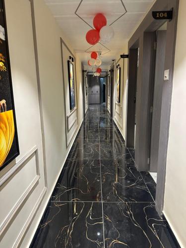a hallway with black marble flooring in a hotel at Hotel Shyam Paradise in Vadodara