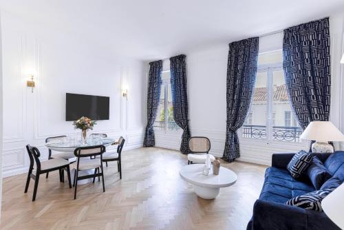 un salon avec un canapé bleu et une table dans l'établissement Le Suite Napoléon - Luxe et Sérénité au Cœur de Cannes, à Cannes