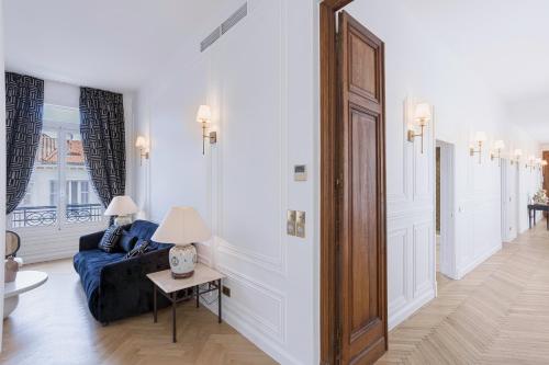 un salon avec un canapé bleu et une table dans l'établissement Le Suite Napoléon - Luxe et Sérénité au Cœur de Cannes, à Cannes