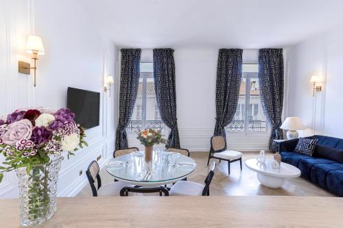 un salon avec une table et un canapé bleu dans l'établissement Le Suite Napoléon - Luxe et Sérénité au Cœur de Cannes, à Cannes