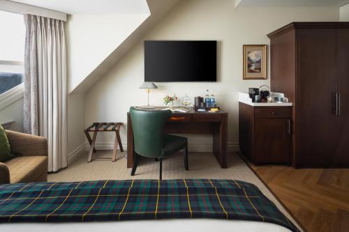 a hotel room with a desk and a bed at Seaton House - Small Luxury Hotels of the World in St. Andrews