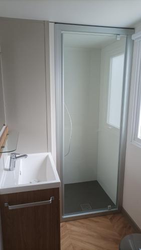 une salle de bain avec une douche en verre et un lavabo dans l'établissement MH 480 2ch 2sdb 40m2 dans camping 4 étoiles avec parc aquatique, à Saint-Julien-en-Born