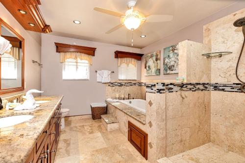 un bagno con vasca, doccia e lavandino di Hol Chan Reef Oceanfront Residences a San Pedro