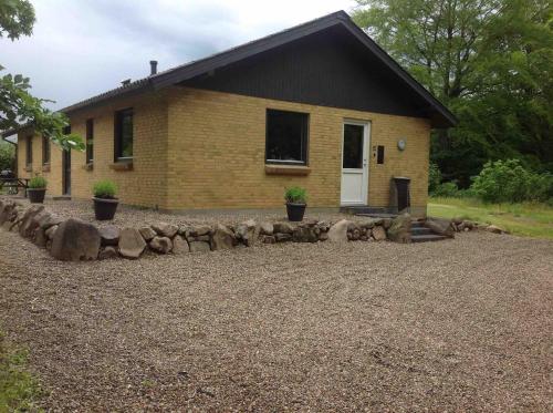 a house with a rock wall in front of it at Privat hus mellem Legoland og Givskud Zoo in Gadbjerg
