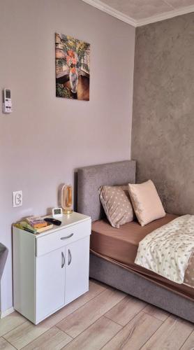 a small bedroom with a bed and a table at Apartmani IMW in Zaječar