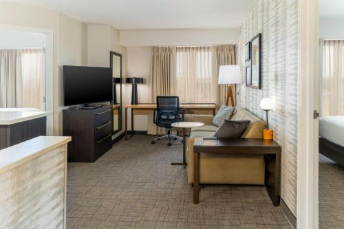 a hotel room with a bed and a living room at Residence Inn Dayton North in Dayton