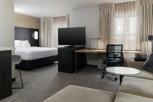 a hotel room with a bed and a desk with a tv at Residence Inn Dayton North in Dayton