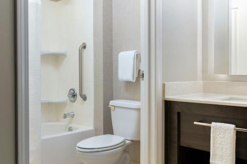 a white bathroom with a toilet and a sink at Residence Inn Dayton North in Dayton