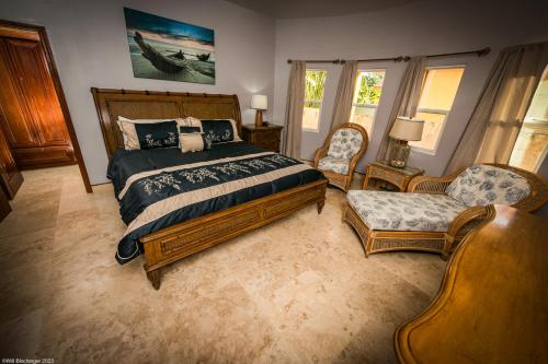 una camera da letto con un letto grande e due sedie di Hol Chan Reef Oceanfront Residences a San Pedro