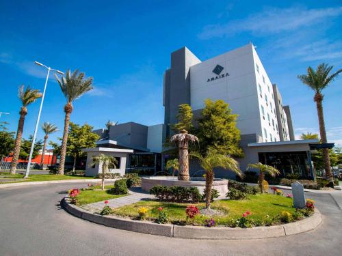 a street in front of a building with palm trees at Hotel Araiza San Luis R.C. in San Luis Río Colorado