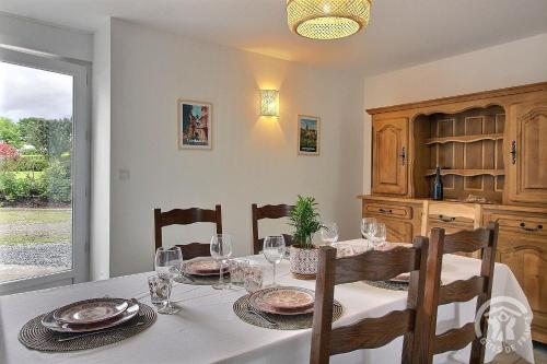 a dining room with a table and chairs and a window at Les dezees in Saint-Udy