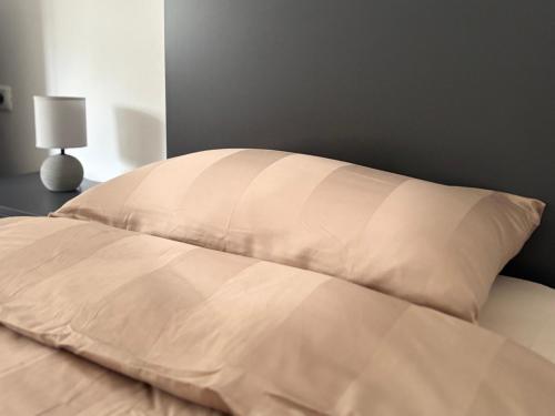 a bed with a pillow on top of it at Qerret Sands Apartment in Golem