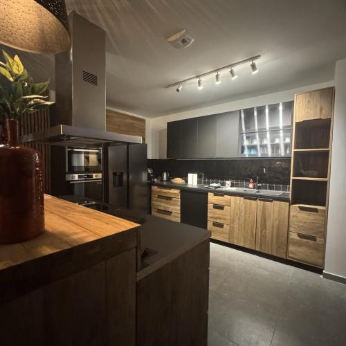 a large kitchen with black appliances and wooden cabinets at Résidence Alissa Charleroi Airport in Charleroi