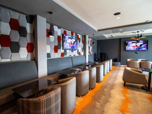 a waiting room with a row of chairs and televisions at Hotel Araiza San Luis R.C. in San Luis Río Colorado