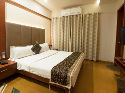 a bedroom with a large bed and a television at Uddhav Vilas A Family Hotel in Udaipur