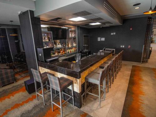 a bar with a bunch of chairs around it at Hotel Araiza San Luis R.C. in San Luis Río Colorado