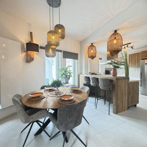 a kitchen and dining room with a wooden table and chairs at Résidence Alissa Charleroi Airport in Charleroi