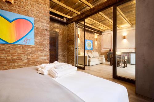 a bedroom with a white bed in a brick wall at Red Moon-Emme Loft in Milan