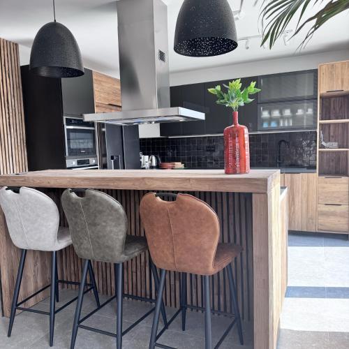 a kitchen with a wooden counter with stools at Résidence Alissa Charleroi Airport in Charleroi