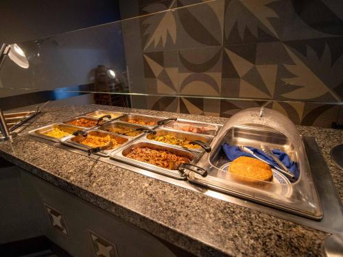 a buffet with trays of food on a counter at Hotel Araiza San Luis R.C. in San Luis Río Colorado