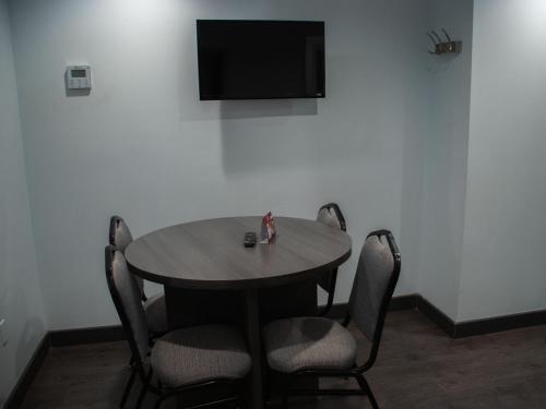 a table with chairs and a television on a wall at Hotel Araiza San Luis R.C. in San Luis Río Colorado