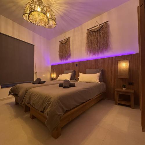 a bedroom with a large bed with purple lighting at Résidence Alissa Charleroi Airport in Charleroi