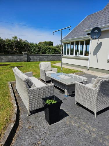 a patio with wicker chairs and a coffee table at Doolin Vista House in Doolin
