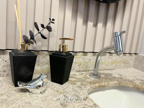 a bathroom counter with two vases and a sink at Beach Haus in Tambaú