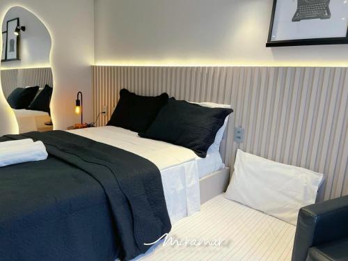 a bedroom with a large bed and a chair at Beach Haus in Tambaú