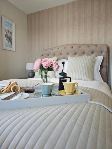 a bedroom with a bed with a table with flowers on it at Doolin Vista House in Doolin