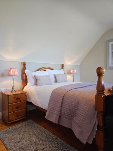 a bedroom with a large bed with two lamps at Doolin Vista House in Doolin