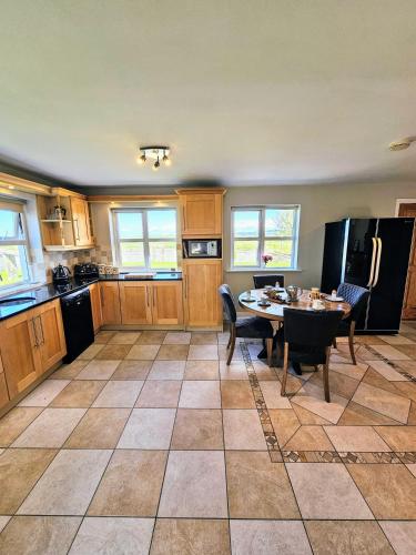 a kitchen with a table with chairs and a refrigerator at Doolin Vista House in Doolin